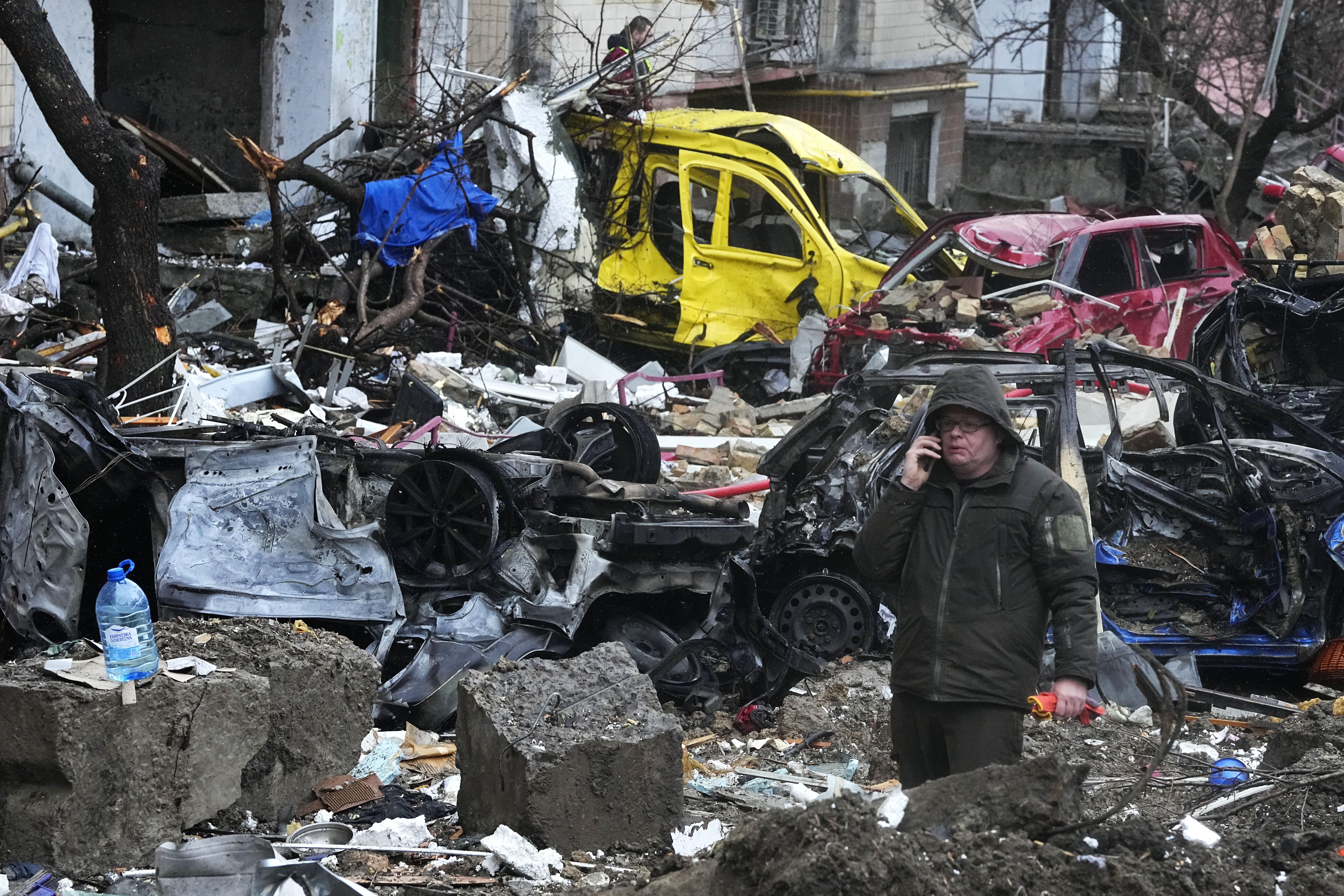 Рятувальники ліквідують наслідки ракетних ударів по Києву 2 січня. / © Associated Press